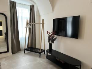 a living room with a tv on the wall at Residence London 1891 - design apartments in Karlovy Vary
