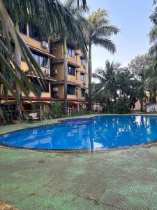 a large blue swimming pool in front of a building at Vihaa - Boutique Stay in Vagator