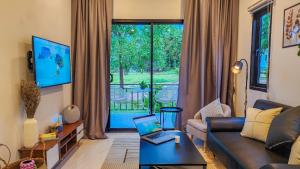 Una sala de estar con un sofá y una computadora portátil sobre una mesa. en Modern Zen Houses Soft mattress 900 Mbps 10min beach, en Ko Pha Ngan