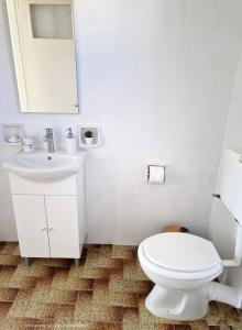 a white bathroom with a toilet and a sink at Michael's Home Cycladic Cottage House in Kini
