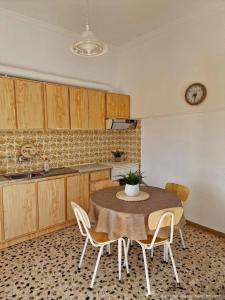 a kitchen with a table and chairs and a clock on the wall at Michael's Home Cycladic Cottage House in Kini +54 photos