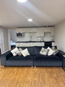 a living room with a blue couch and a kitchen at Cosy Cloud in Congleton
