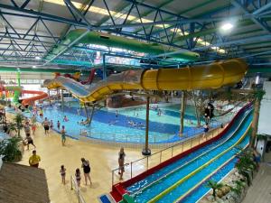 a large pool with a slide in a water park at Cosy Cloud in Congleton