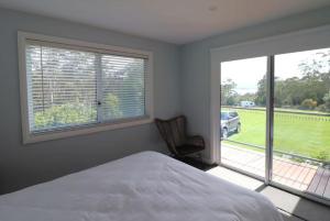 a bedroom with a bed and a window with a view at 19 Blackwood Drive in Mallacoota