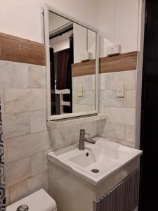 a bathroom with a sink and a mirror and a toilet at The Haven Hostel in Boracay