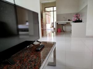 a living room with a large flat screen tv at villa beringin by andi tour in Sampal 2