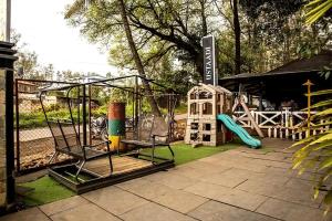 einen Spielplatz mit Rutsche und Schaukel in der Unterkunft Basilica Resort - Where Luxury Redefines in Mahabaleshwar