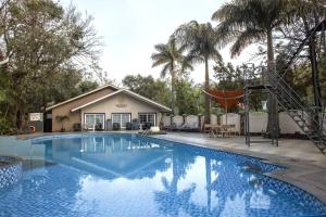 einen Pool mit Spielplatz und ein Haus in der Unterkunft Basilica Resort - Where Luxury Redefines in Mahabaleshwar