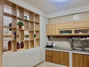 a kitchen with wooden cabinets and a sink at Hung Phu Home & Apartment in Cái Răng