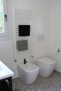 a white bathroom with a toilet and a sink at Casa San Martino in Arizzano