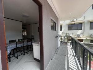 a balcony of a house with a kitchen and a table at Xavier's Place Two in Coron