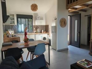 a kitchen and living room with a table and chairs at L'Escale des Bambous in Saint-Paul