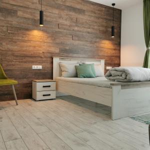 a bedroom with a bed and a wooden wall at Freya House Valea Avrigului in Avrig