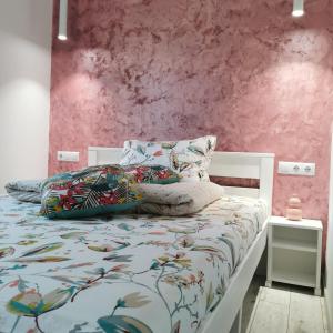 a bedroom with a white bed with a pink wall at Freya House Valea Avrigului in Avrig