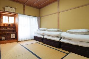 una stanza con tre materassi sovrapposti l'uno all'altro di Golden Fox Inn, Old house in the old city, Walking distance to Matsumoto Castle and tourist attractions a Matsumoto
