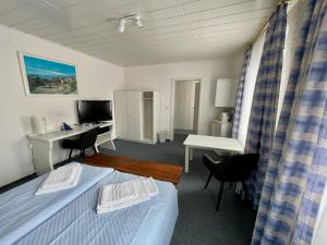 a room with two beds and a desk and a computer at Gästehaus Wilhelma in Gießen