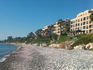 a rocky beach with buildings in the background at Danit apartmnt by the sea in Zygi