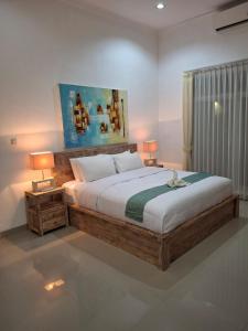 a bedroom with a large bed with two lamps at 3BR Villa Private Swimming pool in Umeanyar