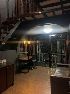 a room with a staircase and a chair and tables at Baan ratchapreuk 2 in Ban Sam Kong