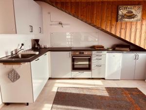 a kitchen with white cabinets and a sink at Ferienwohnung Alpenblick in Pürgen