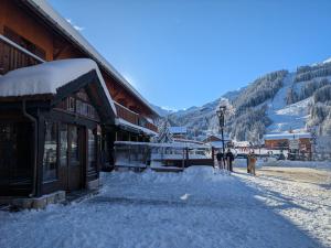a snow covered street in front of a building at Hôtel Les Grangettes in Méribel