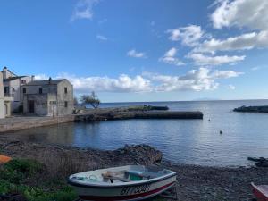a boat sitting on the shore of a body of water at Maison à Porticciolo, idéale pour un couple in Cagnano +2 photos