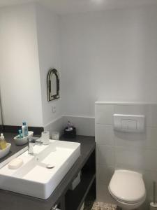 a bathroom with a white sink and a toilet at Maison à Porticciolo, idéale pour un couple in Cagnano