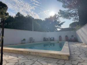 una piscina junto a una pared blanca y una pared blanca en Villa arborée - piscine, en Saint-Jean-de-Védas