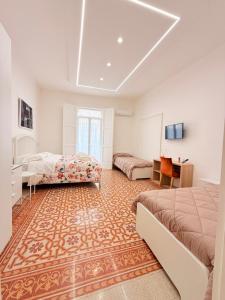 a bedroom with two beds and a desk and a tv at Ideal Suite 41 Pagani in Pagani