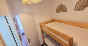 ein kleines Schlafzimmer mit einem Etagenbett und einem Kronleuchter in der Unterkunft Studio Belles Plages 1 ère ligne climatisé in La Grande-Motte