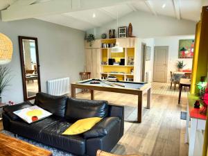 a living room with a couch and a ping pong table at Villa 3 Mats in Dolus-d'Oléron