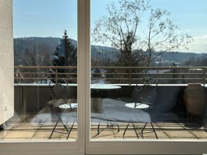 a view from a window of a balcony with a table at Flow Living Penthouse in See- und Bahnhofsnähe in Herrsching am Ammersee