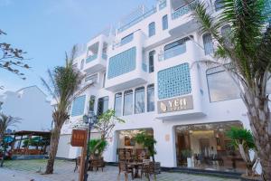 a white building with palm trees in front of it at Yen Hotel in Tuy Hoa