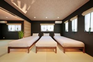 2 letti in una camera con pareti e finestre nere di 千鳥3号天然温泉付別荘 a Shirahama