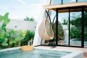 a swimming pool with two rattan chairs next to a house at Antwans Cabin in Tuy