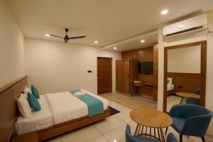 a bedroom with a bed and a table and chairs at Stayon Hotels in Palakkad