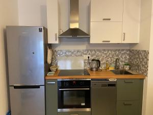 eine Küche mit Kühlschrank und Herd in der Unterkunft Nouveau F2 au calme proche Paris in Montigny-lès-Cormeilles + 4 Fotos