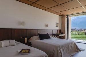 大理Free To Be Wild Designer Hotel的一间有两张床和一扇大窗户的卧室
