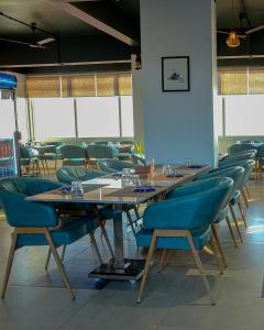 a dining room with wooden tables and blue chairs at Agastya Sea View Resort & Spa in Harnai