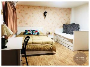 a bedroom with two beds and a desk at Homestay Riceberry Ramintha in Ban Baen Phichit
