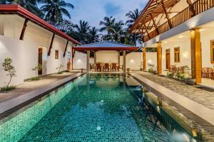 a swimming pool in a villa with a house at The Mansion Koggala in Koggala