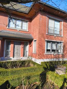 a red brick house with a door and windows at Spelaan in Zottegem