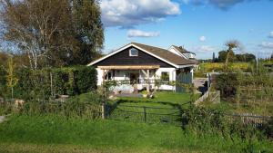 a house with a fence in a yard at De Lindenhof in Tienhoven