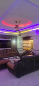 a living room with a couch and purple lights at Akouba in Adido Gomé