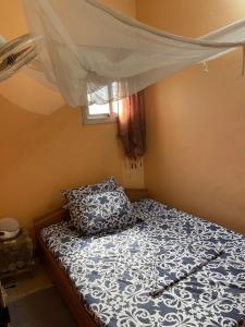 a small bedroom with a bed with a canopy at Vicky Appartements Palmengarten Douala Maképè Belavie in Douala