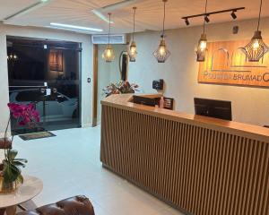 a restaurant with a reception counter and pendant lights at Pousada Brumado in Brumado