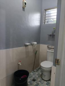 a bathroom with a toilet and a black bucket at Spy Balay 2x Homestay in Butuan