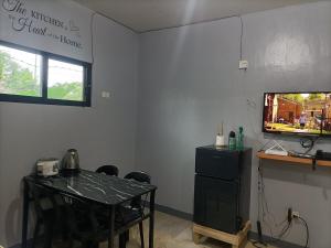 a dining room with a table and a television at Spy Balay 2x Homestay in Butuan
