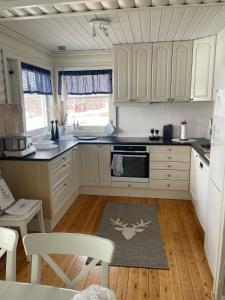 a kitchen with white cabinets and a kitchen rug at Hytte i Altafjorden in Alta +24 photos
