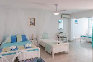 ein Schlafzimmer mit zwei Betten und einem Tisch in der Unterkunft Paroscarmel studio-apartment in Logaras